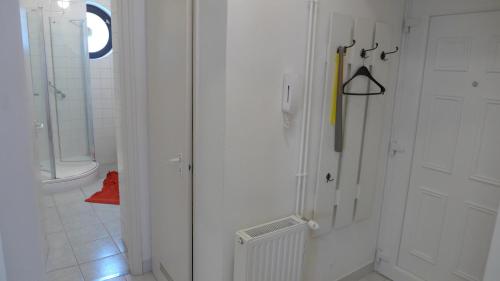 a bathroom with a white door and a yellow umbrella at City Vendégház Mohács in Mohács