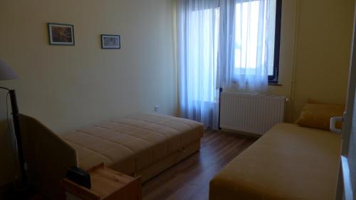 uma sala de estar com uma cama e um sofá em City Vendégház Mohács em Mohács