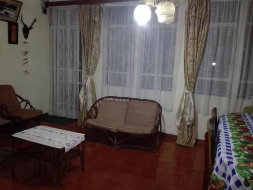 a room with a chair and a bed and windows at Maison Au pied du Volcan in Curepipe