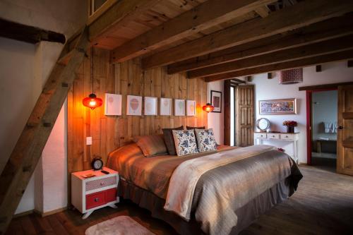 1 dormitorio con 1 cama en una habitación con paredes de madera en Mexicanos 10 CasaVieja, en San Cristóbal de Las Casas