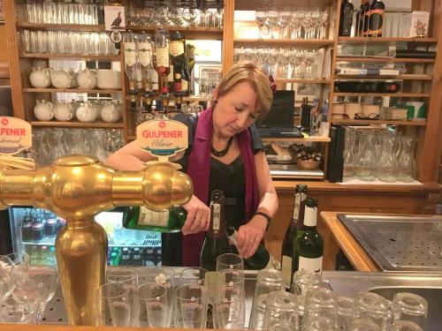 a woman pouring a bottle of wine in a bar at Hotel & Restaurant De Fortuna in Edam