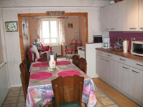 a kitchen and dining room with a table and a room at Vacances au pied des Monts du Cantal in Laveissière