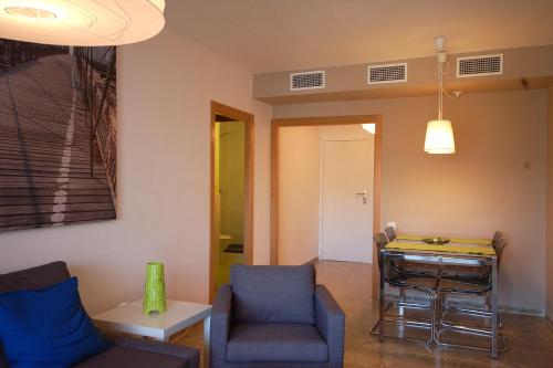 ein Wohnzimmer mit einem Tisch und Stühlen in der Unterkunft Lets Holidays New Flat Beachfront In Castelldefels in Castelldefels