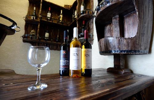 three bottles of wine and a glass on a table at Atlant Hotel in Tbilisi City