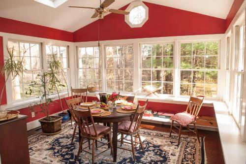 a dining room with red walls and a table and chairs at Orchard Inn in Saluda