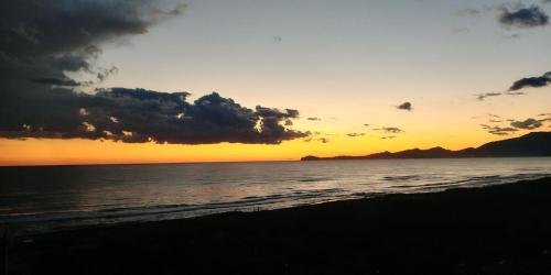 a sunset on the beach with the ocean at Domizia Palace Hotel in Baia Domizia
