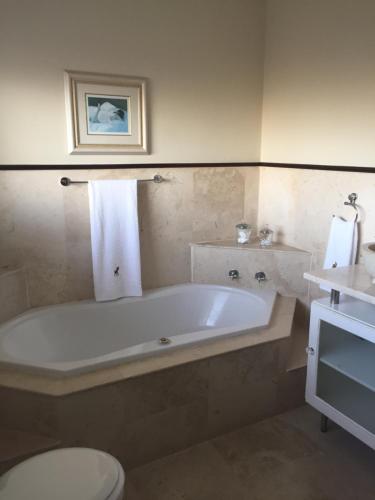 Un baño con bañera, inodoro y lavabo. en Roman Retreat, en Ciudad del Cabo