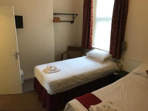 a hotel room with two beds and a window at The Island & Fairfield in Douglas