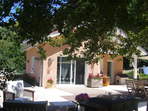 a building with tables and chairs under a tree at Le Jardin Ombragé in Saint-Paul-dʼIzeaux