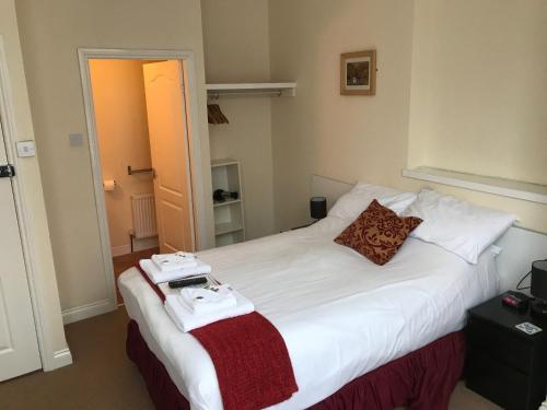 a bedroom with a white bed with two towels on it at The Island & Fairfield in Douglas