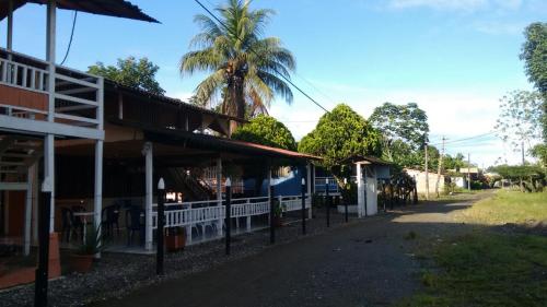 a row of buildings with a palm tree in the background at Hotel Palmas del Pacifico in Nuquí