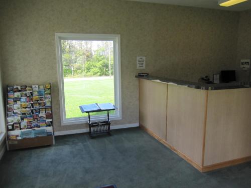 a waiting room with a large window and a table at Embassy Inn Motel Ithaca in Ithaca