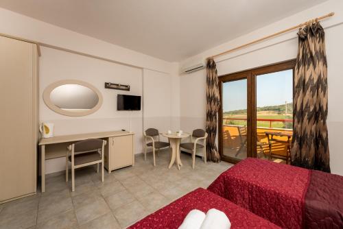 a hotel room with a bed and a table and a window at Petrinos Lofos in Mándra