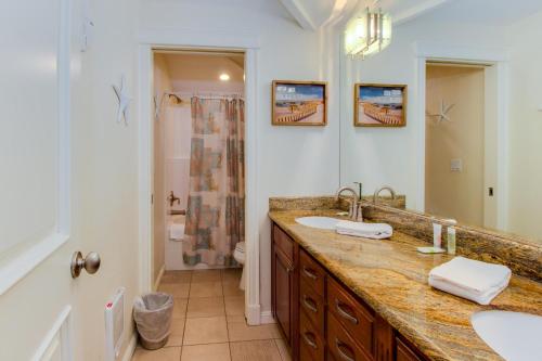 un bagno con due lavandini e un grande specchio di Beach Villa - Three Bedroom a Rockaway Beach