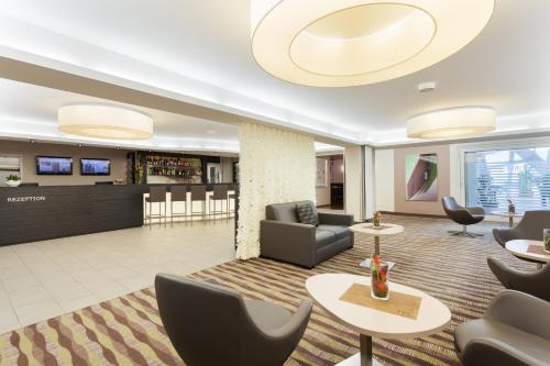 a lobby of a hotel with chairs and tables at Mercure Hotel am Entenfang Hannover in Hannover