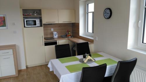 a kitchen with a table and chairs in a room at APARTMÁNY NA VÝSLUNÍ in Horní Maxov