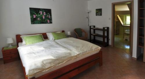 1 dormitorio con 1 cama grande con almohadas verdes en Penzion Lazy Daisy, en Janov nad Nisou