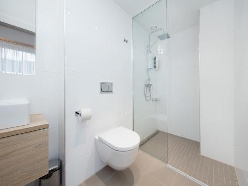 a white bathroom with a toilet and a shower at 8ERA Business Executive Rotermanni Apartments in Tallinn