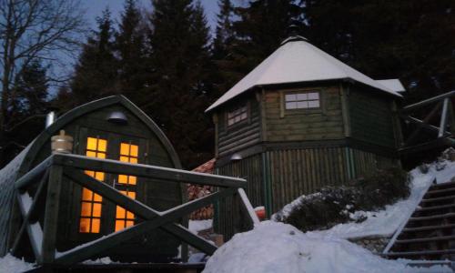 a small cabin with lights on in the snow at Penzion Lazy Daisy in Janov nad Nisou