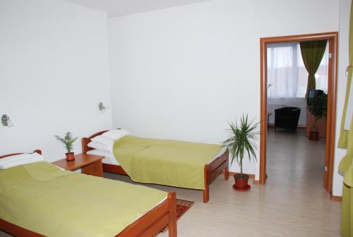 Habitación de hotel con 2 camas y espejo en M Garni Hotel, en Vranje