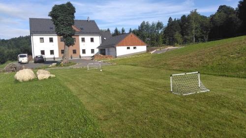 a soccer ball in a field in front of a house at APARTMÁNY NA VÝSLUNÍ in Horní Maxov