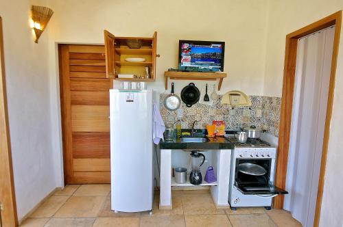 a kitchen with a white refrigerator and a stove at Villa Medina Jeri in Jericoacoara