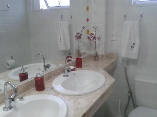 een badkamer met 2 wastafels en een toilet bij Reserva Imbassaí Vila dos Lirios in Imbassai