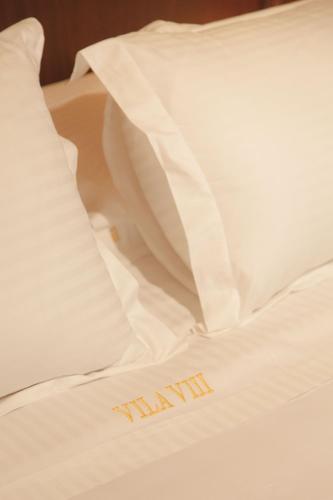 a bed with a pillow with the word yawn written on it at Hotel Boutique Vila 8 in Durrës