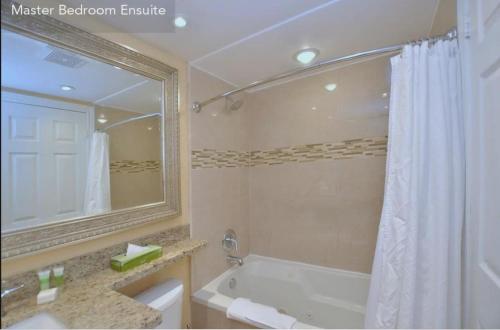 y baño con bañera, lavabo y espejo. en Large modern ground floor condo at Mountain Walk, en Blue Mountains