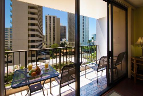 a balcony with a table with fruit on it at Waikiki Sunset Mountain View Near Beach with Parking in Honolulu