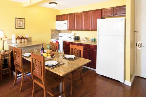 a kitchen with a table and a white refrigerator at Waikiki Sunset Mountain View Near Beach with Parking in Honolulu