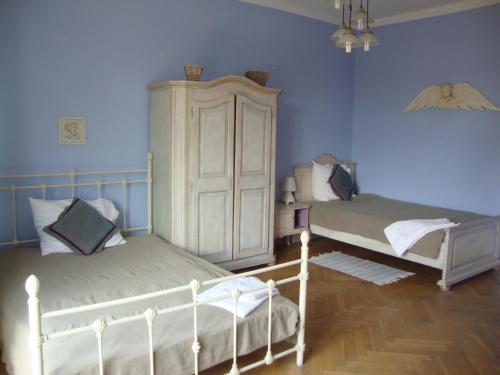 due letti in una stanza con pareti blu di Belle Epoque a Poznań