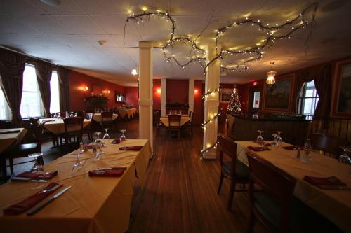 a restaurant with tables and chairs and a chandelier at Smugglers Notch Inn in Jeffersonville