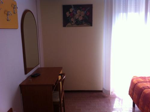 a room with a desk and a mirror and a bed at Hotel Viking in Rimini