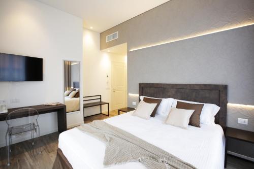 a bedroom with a large white bed and a desk at Villa Liberty in Como