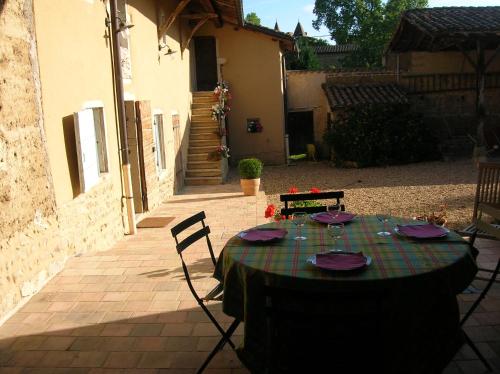 - une table avec des assiettes et des serviettes sur une terrasse dans l'établissement Bed & Breakfast - Maison de Marie, à Messimy