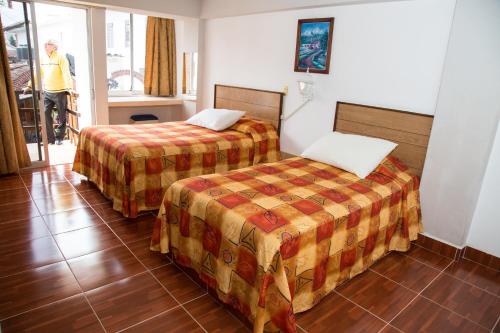 ein Hotelzimmer mit 2 Betten und einem Fenster in der Unterkunft Hotel Symer in Chignahuapan