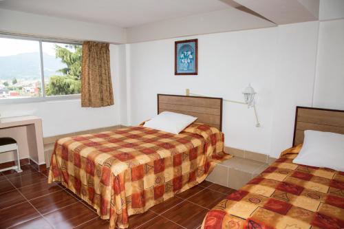 a hotel room with two beds and a fireplace at Hotel Symer in Chignahuapan