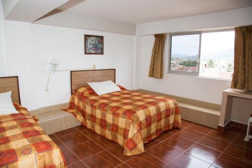 1 dormitorio con 2 camas y ventana en Hotel Symer en Chignahuapan