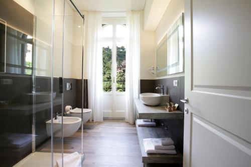 a bathroom with two sinks and a glass shower at Villa Liberty in Como