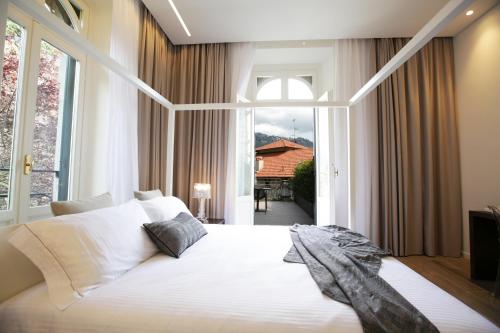 a bedroom with a white bed and a large window at Villa Liberty in Como