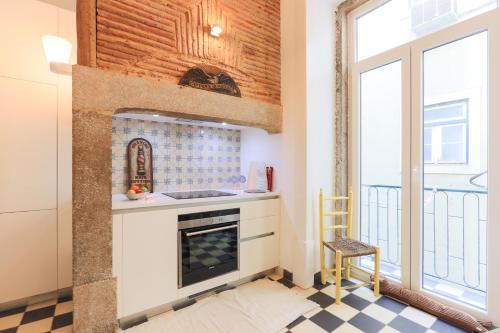 una cocina con estufa horno superior al lado de una ventana en Lisbon Secret & Charming Baixa 4 bedroom apartment, en Lisboa