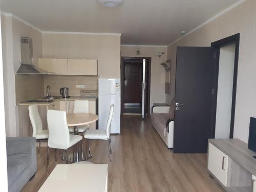 a kitchen and living room with a table and chairs at Viva Blue Batumi in Batumi