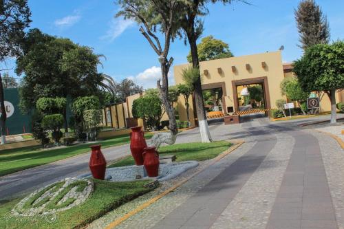 a street with three red vases on the side of a road at Casa Cantarranas in Tehuacán
