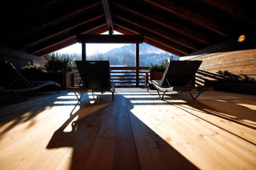 two chairs on a deck with a view of mountains at Zin Senfter Residence in San Candido