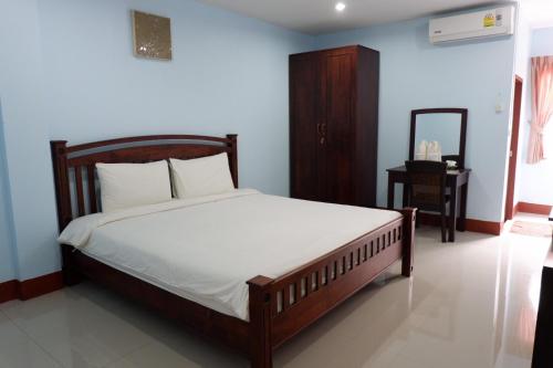 a bedroom with a bed and a mirror in it at Na Chaidej hotel in Suratthani