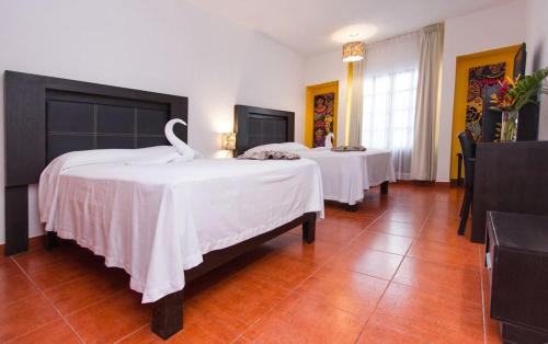 a room with two beds with swans on them at Hotel Santa Cruz Huatulco in Santa Cruz Huatulco