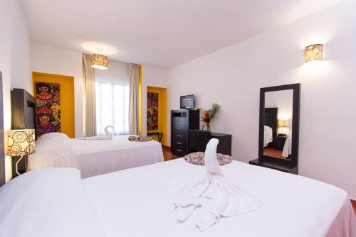 Cette chambre comprend 2 lits et un miroir. dans l'établissement Hotel Santa Cruz Huatulco, à Santa Cruz Huatulco