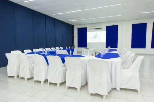 a conference room with white tables and white chairs at Hotel Santa Cruz Huatulco in Santa Cruz Huatulco