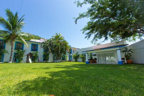 a house with a green lawn in front of it at Hotel Santa Cruz Huatulco in Santa Cruz Huatulco